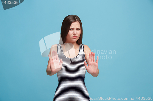 Image of Let me think. Doubtful pensive woman with thoughtful expression making choice against blue background