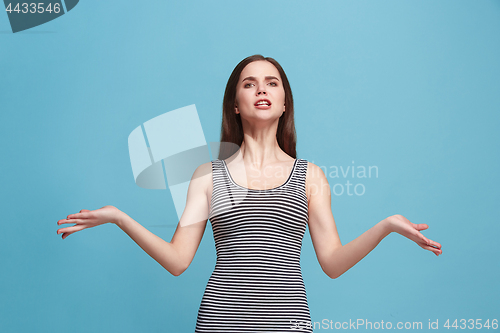 Image of Portrait of an angry woman looking at camera isolated on a blue background