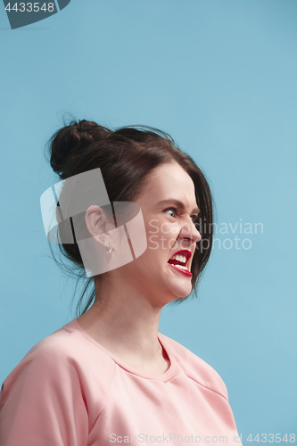 Image of Portrait of an angry woman looking away isolated on a blue background