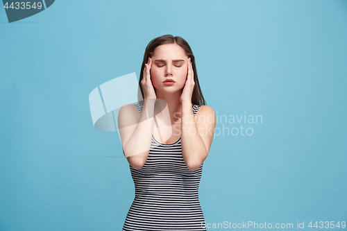 Image of Woman having headache. Isolated over blue background.