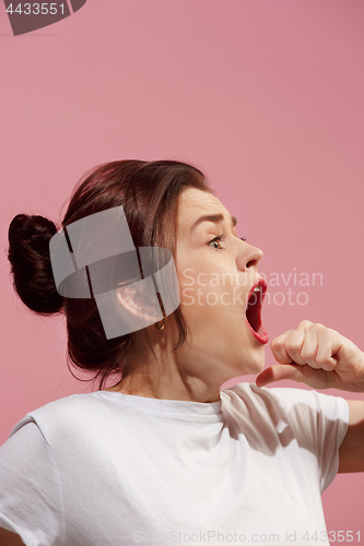 Image of The young emotional angry woman screaming on pink studio background