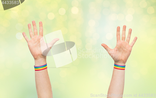 Image of hands with gay pride rainbow wristbands