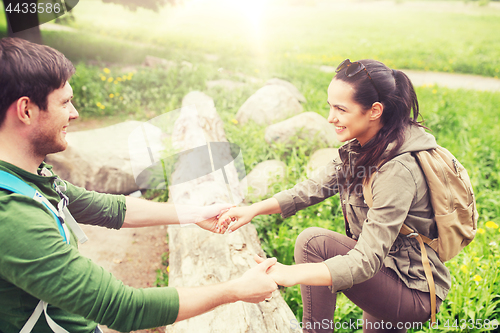 Image of smiling couple with backpacks hiking