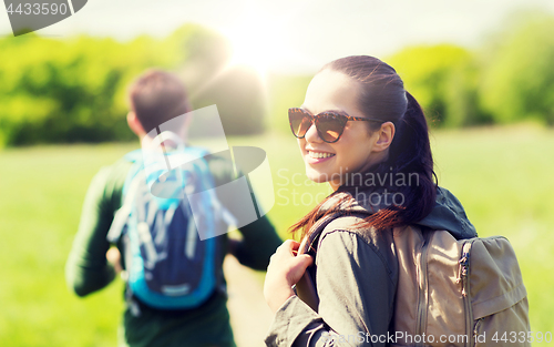 Image of happy couple with backpacks hiking outdoors