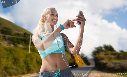 Image of woman with smartphone and earphones doing sports