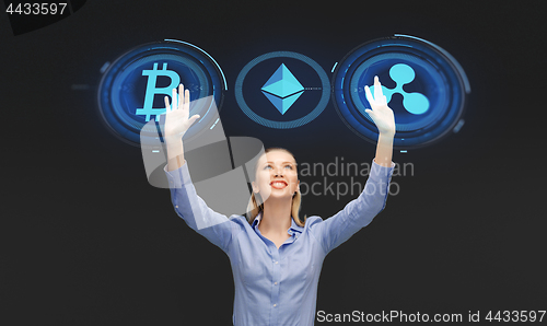 Image of businesswoman with cryptocurrency holograms