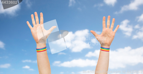 Image of hands with gay pride rainbow wristbands