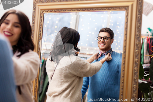 Image of couple choosing clothes at vintage clothing store