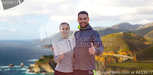 Image of smiling couple in sport clothes showing thumbs up