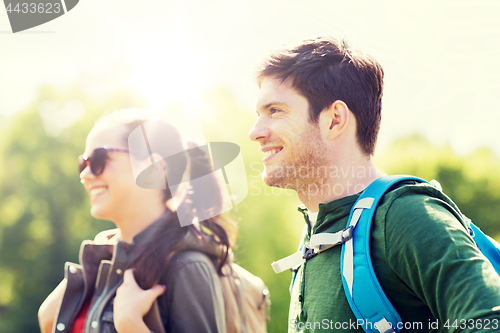 Image of happy couple with backpacks hiking outdoors