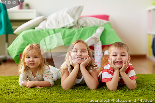 Image of happy little kids lying on floor or carpet