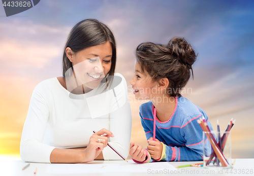 Image of happy mother and daughter drawing over evening sky