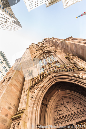 Image of Wide angle upward view of Trinity Church at Broadway and Wall Street with surrounding skyscrapers, Lower Manhattan, New York City, USA