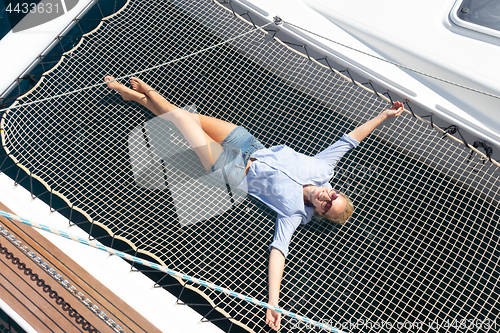 Image of Woman relaxing on a luxury catamaran sailing boat.