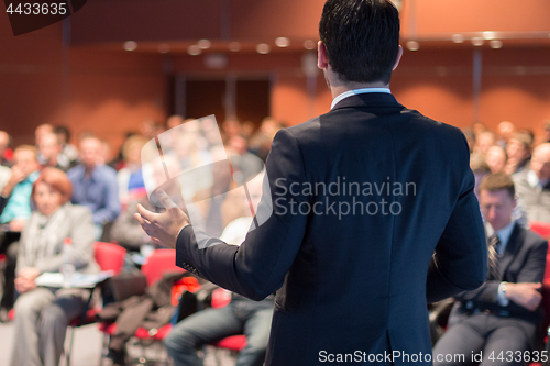 Image of Public speaker giving talk at business event.