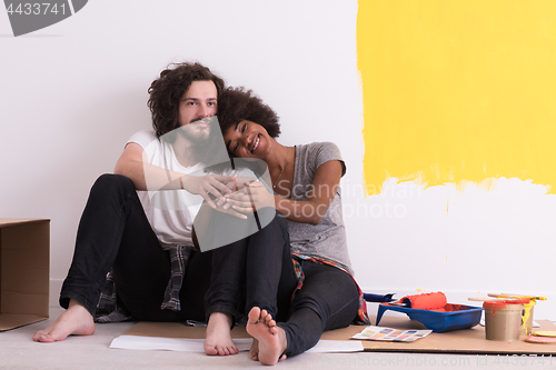 Image of young multiethnic couple relaxing after painting