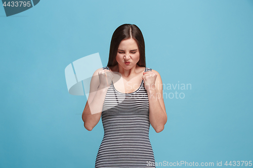 Image of Portrait of an angry woman looking at camera isolated on a blue background