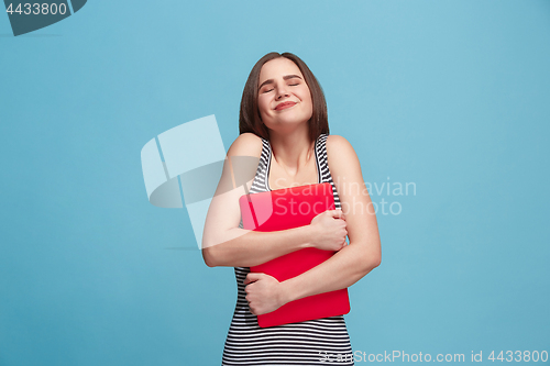 Image of Businesswoman hugging laptop on blue studio