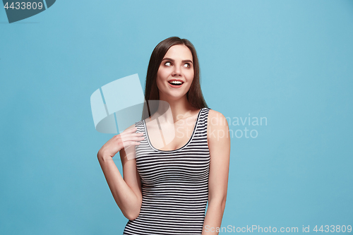 Image of Let me think. Doubtful pensive woman with thoughtful expression making choice against blue background