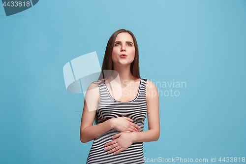 Image of The happy business woman standing and smiling against blue background.