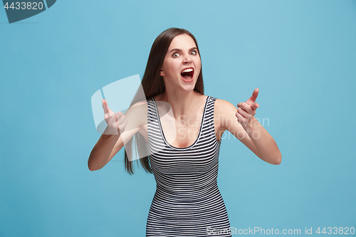 Image of Portrait of an angry woman looking at camera isolated on a blue background