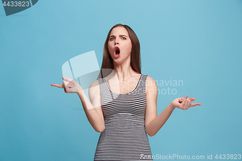 Image of Portrait of an argue woman looking at camera isolated on a blue background