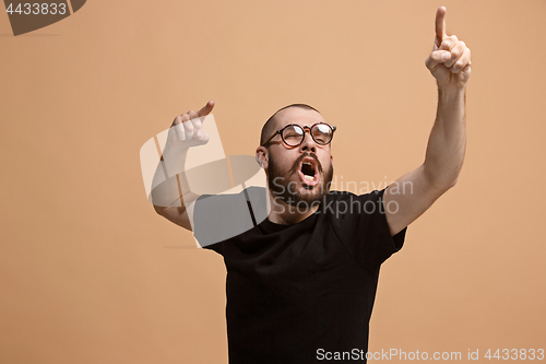 Image of Beautiful male half-length portrait isolated on pastel studio backgroud. The young emotional surprised man