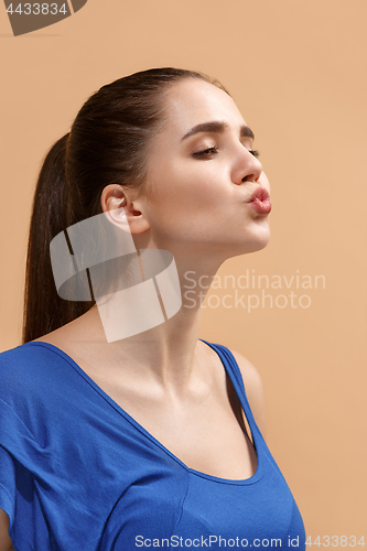 Image of The young woman is looking lovely on the pastel background.