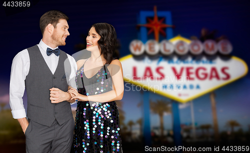 Image of happy couple at party over las vegas sign at night