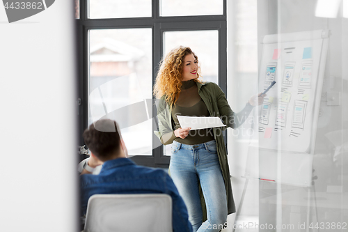 Image of creative woman showing user interface at office