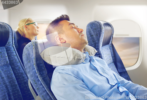 Image of man sleeping in plane with cervical neck pillow