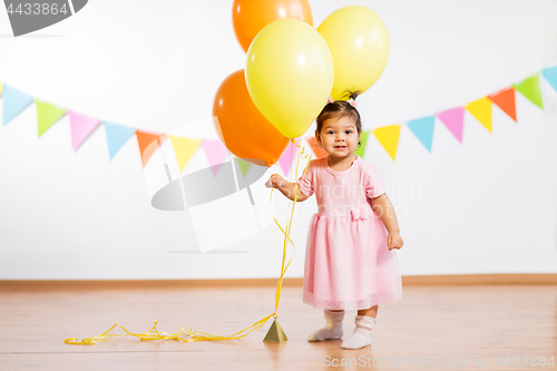 Image of happy baby girl with balloons on birthday party