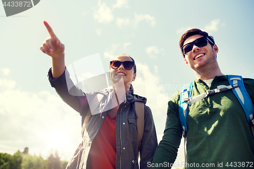 Image of happy couple with backpacks hiking outdoors