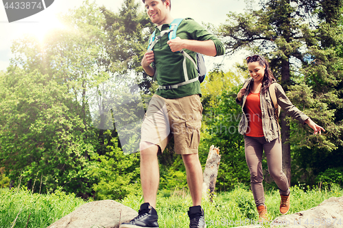 Image of happy couple with backpacks hiking outdoors