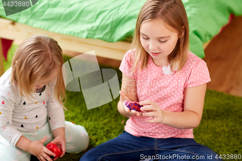 Image of sisters with modelling clay or slimes at home