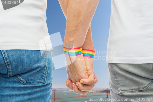 Image of male couple with gay pride rainbow wristbands