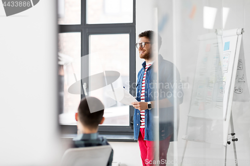 Image of creative man with papers at office presentation