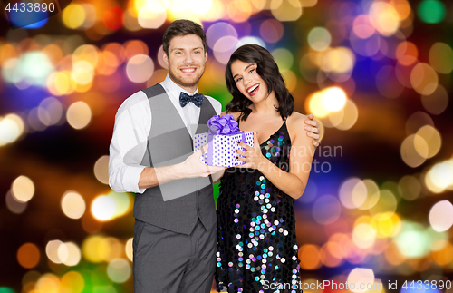 Image of happy couple with gift box at birthday party