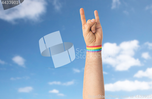 Image of hand with gay pride rainbow wristband shows rock