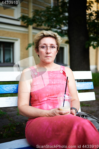 Image of Adult woman using smartphone on bench