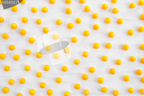 Image of Wild yellow plums on white wooden background