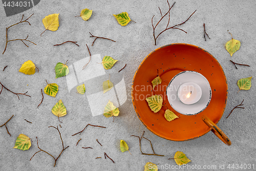 Image of Autumn leaves and cozy candlelight