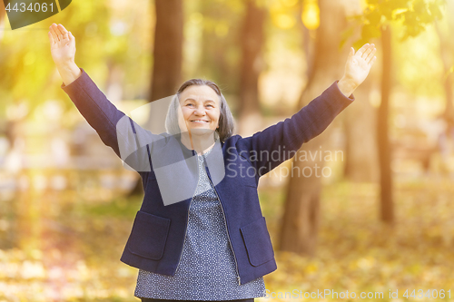 Image of Happy woman with arms outstretched