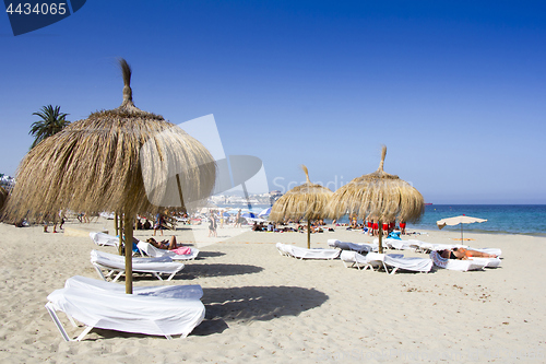 Image of Sunbeds and umbrellas on a beautiful beach in Ibiza