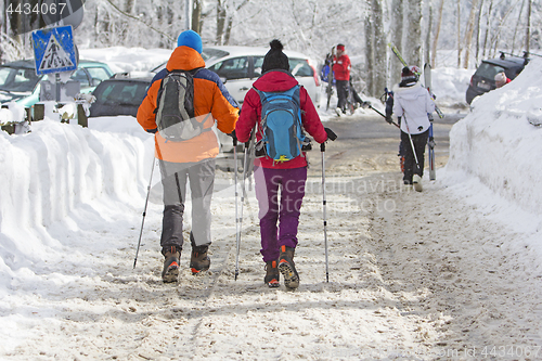 Image of Young couple hiking outside on the snow in winter mountains