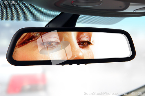 Image of driver looks to rear-view mirror