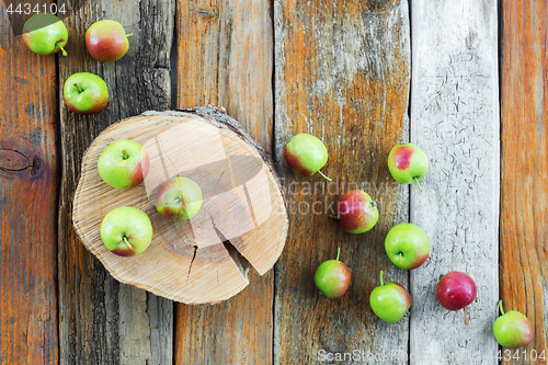 Image of Apple tree stump and apples on rustic wooden background