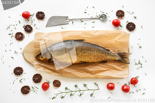 Image of Smoked Omul fish with herbs and tomatoes