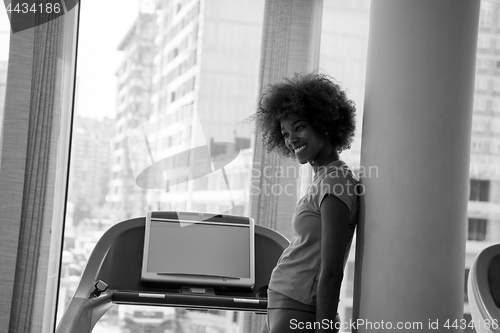 Image of afro american woman running on a treadmill