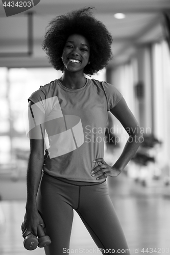 Image of woman working out in a crossfit gym with dumbbells